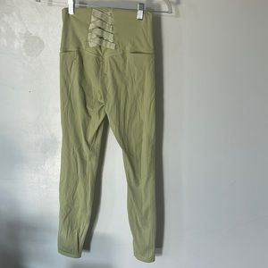 Green leggings with minor pilling and wear.